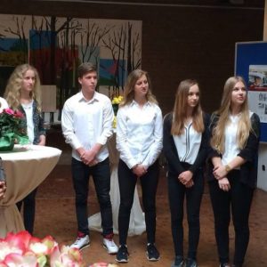 Guido van den Berg MdL (rechts) überreicht die Ausstellung „Der Weg zur Deutschen Einheit“ an Schulleiter Dr. Hummelsheim (links) und Schülerinnen und Schüler des Erftgymnasiums.