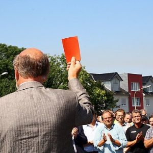 Niederziers Bürgermeister Herrmann Heuser zeigt "gewaltbereiten Aktivisten" symbolisch die rote Karte.
